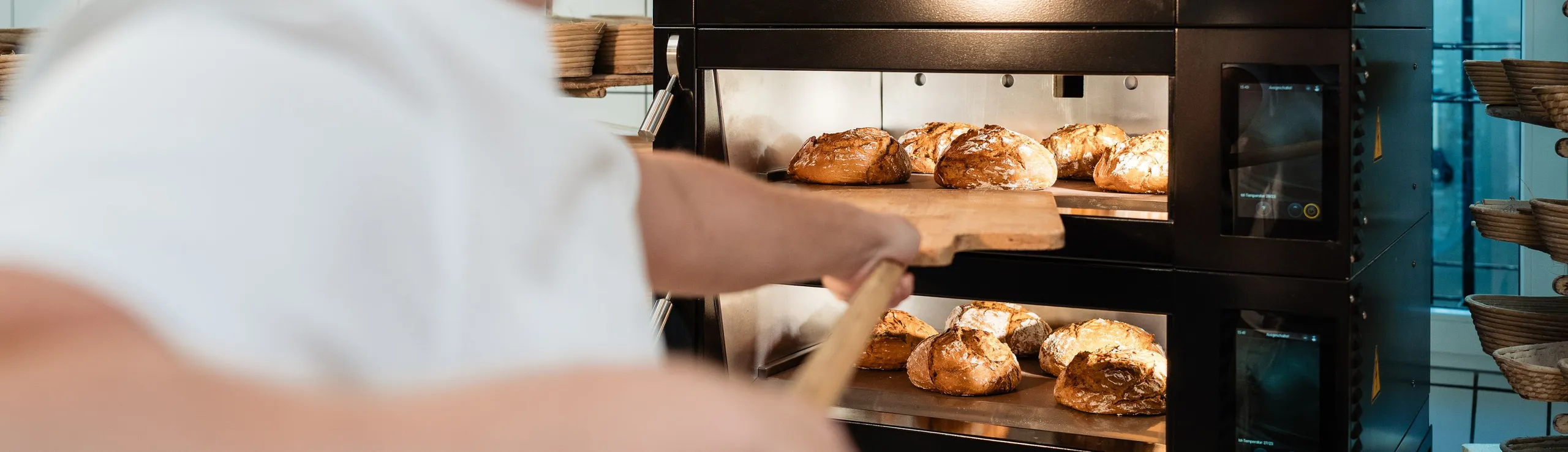 Bäcker vor dem Ofen mit Brot